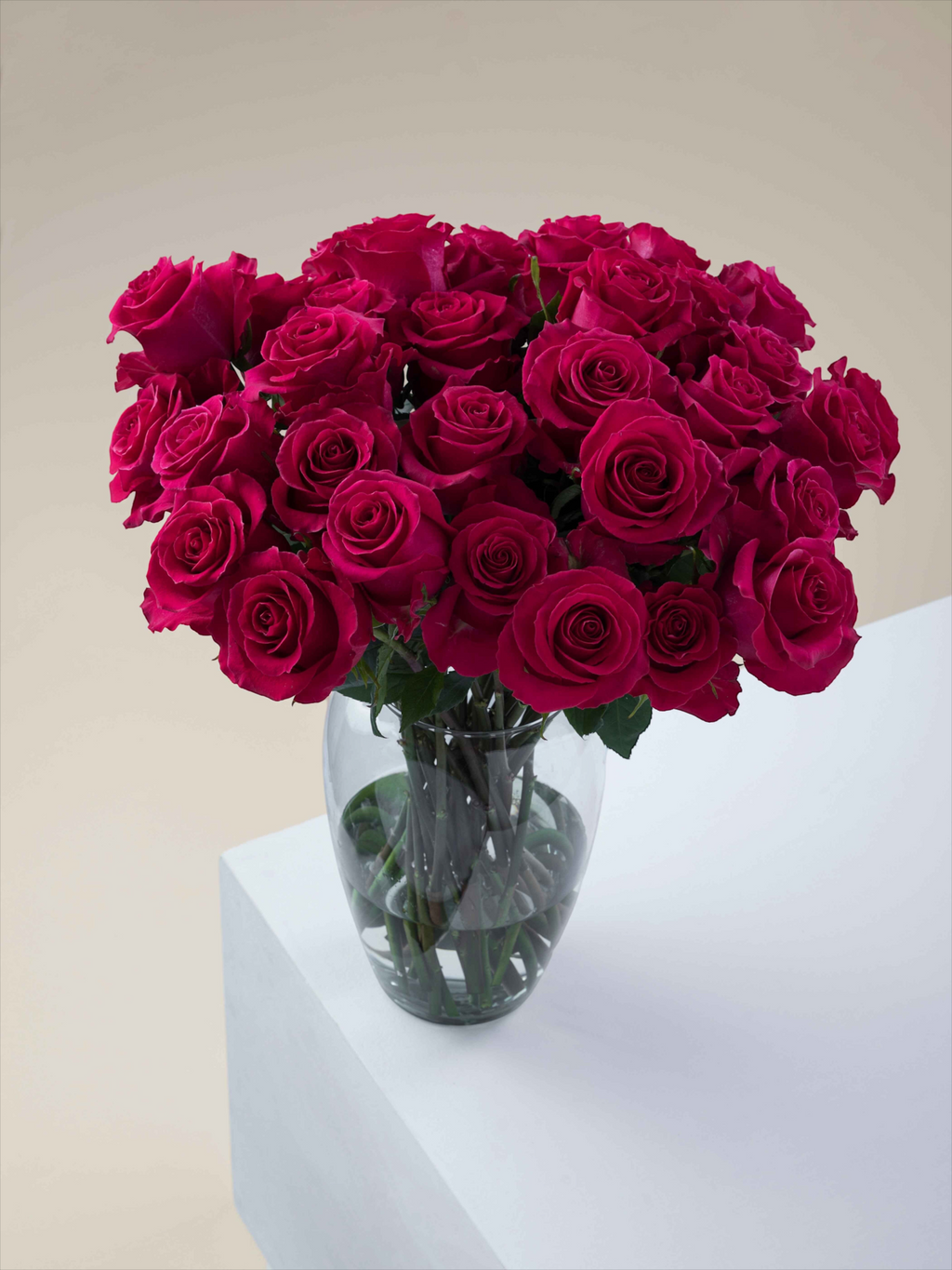 Ramo de rosas fucsia My Store 3 en un florero de cristal sobre una superficie blanca para decoración de eventos