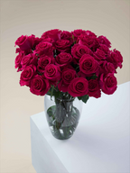 Ramo de rosas fucsia My Store 3 en un florero de cristal sobre una superficie blanca para decoración de eventos